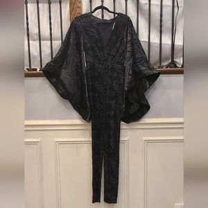 Black sparkly jumpsuit with large statement bell sleeves by: Akira
